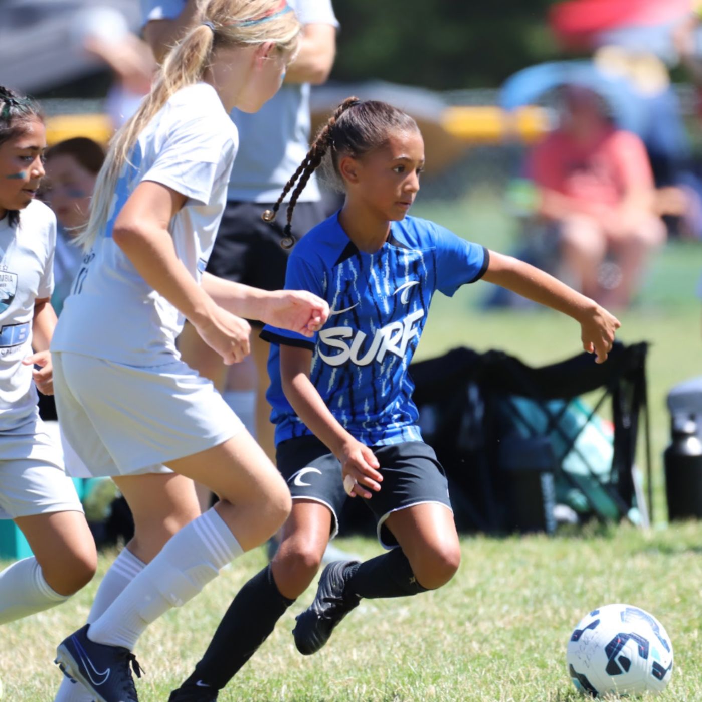 An Oregon Surf player dribbling past a defender
