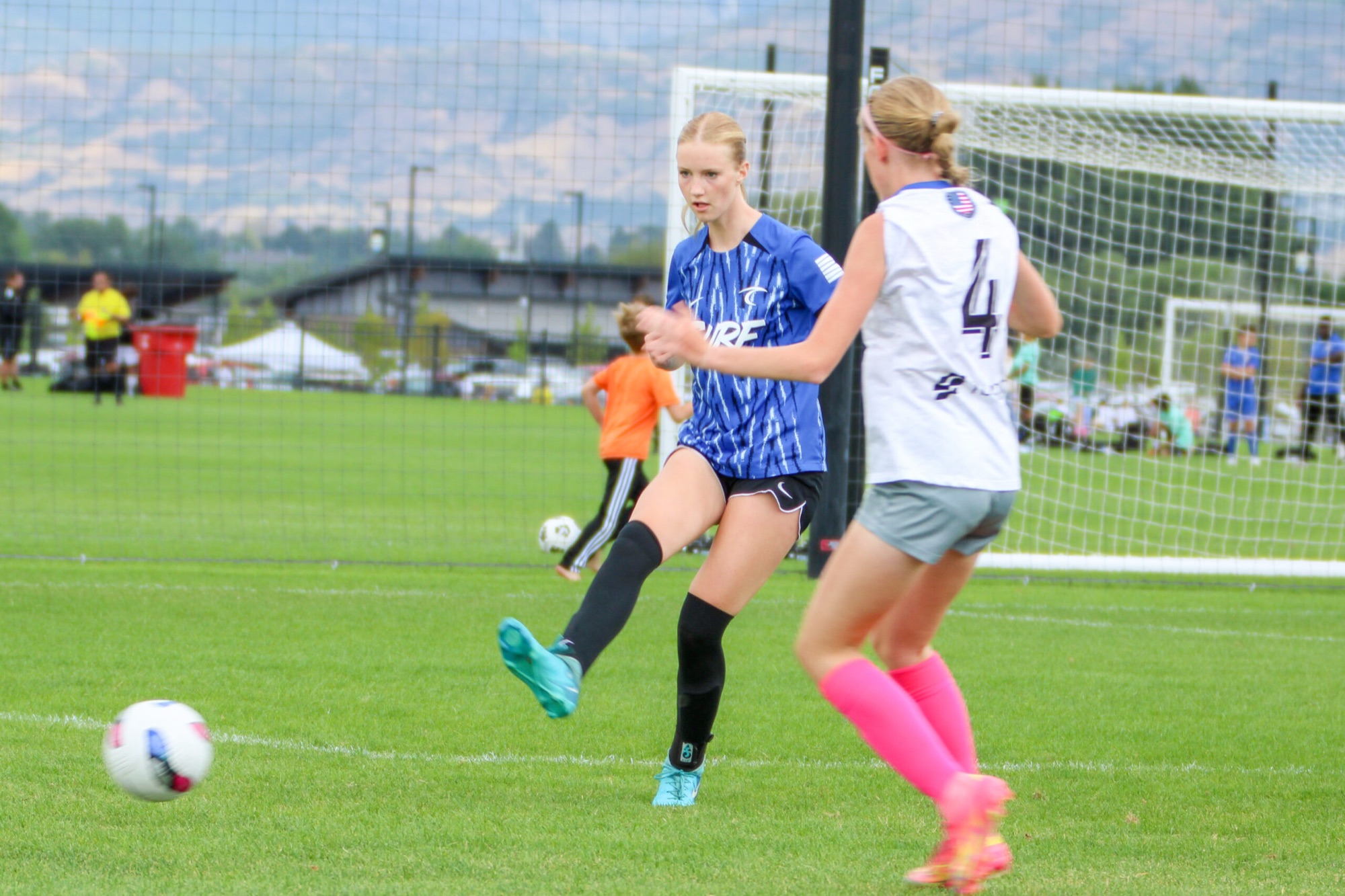 A Utah Surf player in the blue SURF kit striking the ball in a match